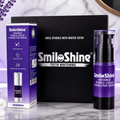 SmileShine Purple Color Corrector Serum shown with its purple and white retail box and the spray bottle, set against a black presentation box on a marble surface with decorative lavender flowers and a white vase.